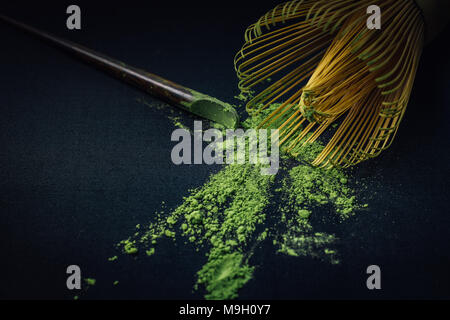 Close up Bambusbesen und Matcha Grüntee Pulver auf schwarzem Hintergrund. Stockfoto