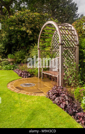 Holz- gitter Sitz Laube, Mosaik Kunst, Rasen & Sommer Grenze Pflanzen in schönen, traditionellen, gestaltet, angelegten Garten - West Yorkshire, England. Stockfoto