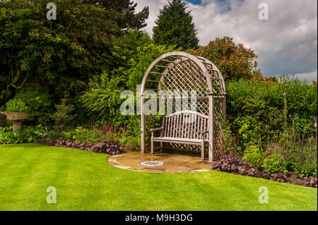 Holz- gitter Sitz Laube, Mosaik Kunst, Rasen & Sommer Grenze Pflanzen in schönen, traditionellen, gestaltet, angelegten Garten - West Yorkshire, England. Stockfoto