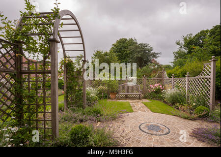 Sommer Pflanzen, Mosaik Artwork, Gitter, Bildschirm, Laube Torbogen & Sitz - schöne, traditionelle, Landschaftsgarten, gestaltete Garten - Yorkshire, England, UK. Stockfoto