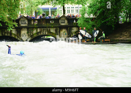 München Deutschland 11. SEPTEMBER 2017; River surfer Herausforderung tosenden Stromschnellen am Eisbach Fluss in der Mitte der Europäischen Stadt, während die Menschen auf der Brücke wat stand Stockfoto