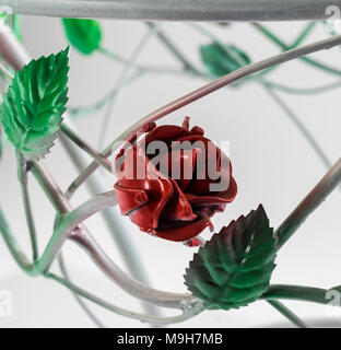 Schmiedeeisen. Schön geschwungenen Ornamenten aus Tabelle, roten Rosen und grünen Blättern Stockfoto