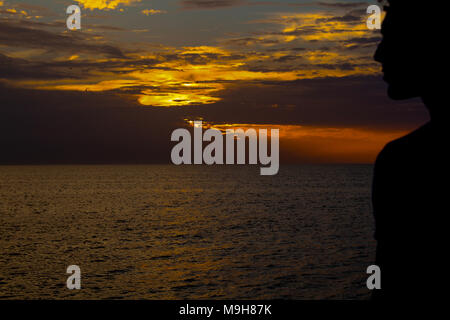 Silhouette eines Mannes peering am Sonnenuntergang. Stockfoto