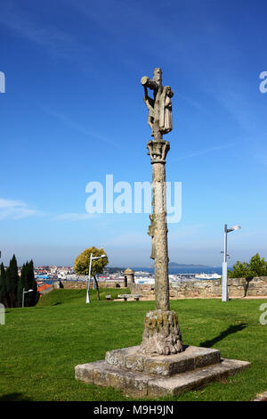 Traditionelles kalvarienkreuz aus regionalem Stein namens Crucero/cruceiro in Castillo de San Sebastian, Ria de Vigo im Hintergrund, Vigo, Galicien, Spanien Stockfoto