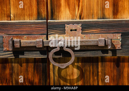 Alte Riegel auf Holztür mit Schlüsselloch Stockfoto