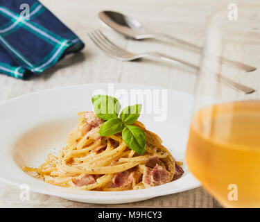 Spaghetti Carbonara auf weißem palte mit Basilikum Blatt Stockfoto