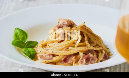 Spaghetti Carbonara auf weißem palte mit Basilikum Blatt Stockfoto