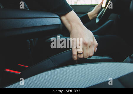 Eine weibliche Hand greift die Handbremse, Parkplatz Stockfoto