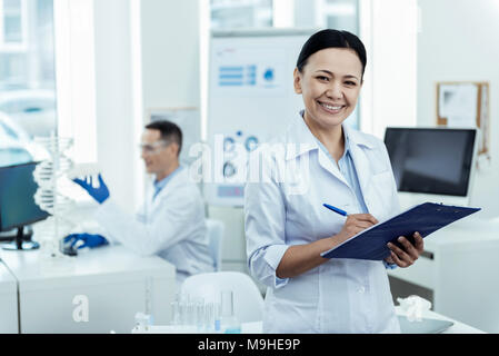 Lächelnd Wissenschaftler im Labor arbeiten mit ihrem Kollegen Stockfoto