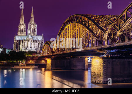 Köln, Deutschland. Nacht Blick auf den Kölner Dom und Hohenzollernbrücke In der blauen Stunde. Römisch-katholische Kathedrale in der Nacht Beleuchtung. UNESCO-Wor Stockfoto