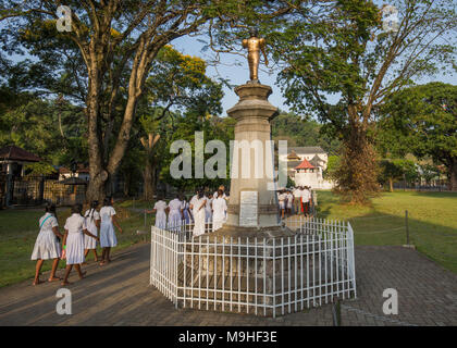 Schülerinnen und Schüler gehen in der Nähe der Statue des Madduma Bandara am Tempel des Zahns, Kandy, Sri Lanka, Asien. Stockfoto