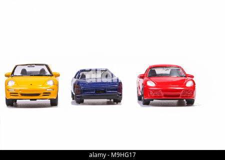 Drei kleine Spielzeugautos auf eine Zeile Stockfoto