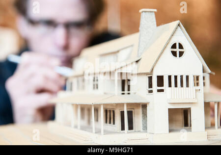 Kaukasische männlichen Architekten auf einer Skala Modell einer neuen zu Hause aus arbeiten. Stockfoto