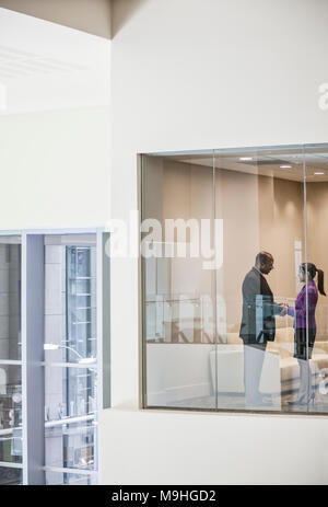 Schwarzer Geschäftsmann und Frau Hände schütteln im Fenster Konferenzraum. Stockfoto