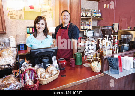 Kaukasische Frau und Mann, Geschäft Inhaber eines Coffee Shop, am Counter. Zeigt an frischen Backwaren. Stockfoto