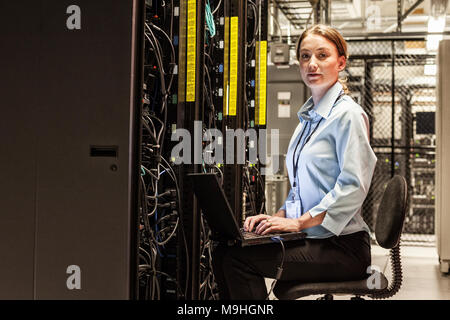 Kaukasische Frau Techniker arbeiten auf dem Server speichern, in einer Serverfarm. Stockfoto
