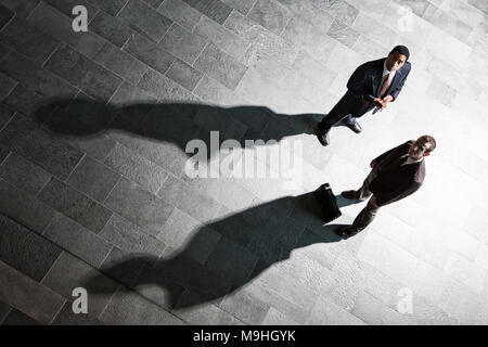 Blick von oben der zwei Geschäftsmänner und Schatten auf dem Boden eines Business Lobby. Stockfoto