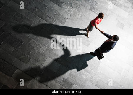 Blick von oben auf ein Händedruck und Schatten zwischen einem Unternehmer und Geschäftsfrau. Stockfoto