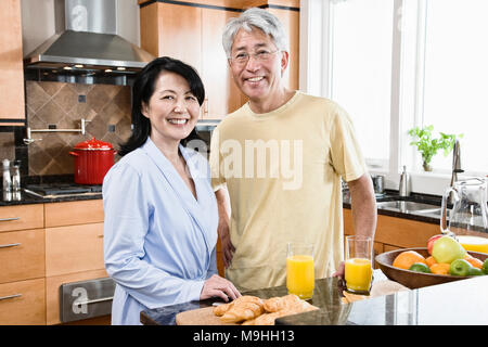 Asiatischer Mann und Frau in Ihrer neuen Küche für Frühstück. Stockfoto