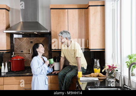 Asiatischer Mann und Frau in Ihrer neuen Küche für Frühstück. Stockfoto