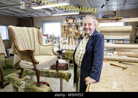 Caucaisan älterer männlichen Polsterer arbeiten auf einem Stuhl in seiner Garage Shop. Stockfoto