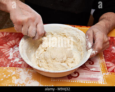Mens Hände kneten Sie den Teig Stockfoto