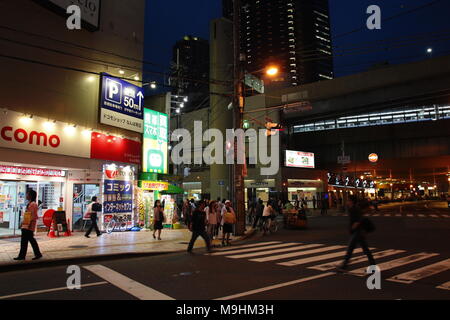 Fußgänger überqueren Sie die Straße über den Zebrastreifen in Osaka, Japan Stockfoto