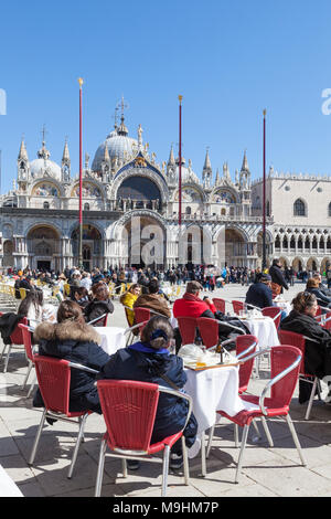 Die Menschen, um einen Drink zu genießen und in der Sonne auf der Piazza San Marco (Markusplatz), Venedig, Venetien, Italien vor der Basilika San Marco (Markusplatz Basilika) Stockfoto