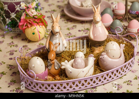 Porzellan Oster bunnys oder Kaninchen mit Eiern auf dem Tisch Stockfoto