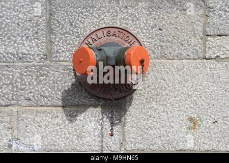 Hydrant an der äußeren Mauer eines Gebäudes. Stockfoto