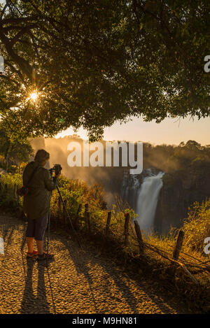 Ein Tourist fotografiert die Victoria Falls, Simbabwe. Stockfoto