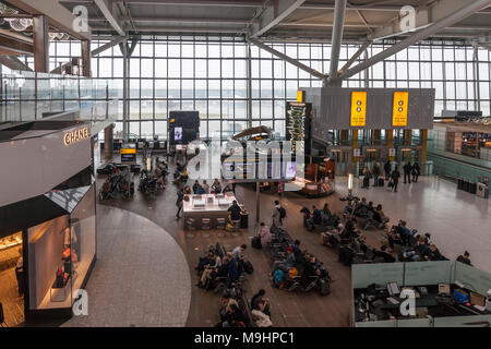 Flugreisende wartet im Abflugbereich des Flughafens Heathrow, Terminal 5. Sitzecke, Telefon Ladestationen, Caviar House, Chanel, Menschen, Stockfoto