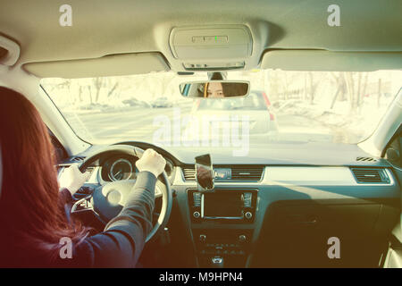 Die Frau, die braunhaarige Auto fahren in sonniger Tag. Stockfoto