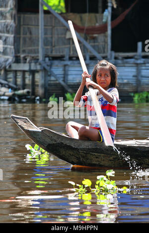 Kind in einem Kanu in Phumĭ Mé Chrey schwimmenden Dorf auf Tonlé Sap See, Ek Phnom, in Battambang, Kambodscha Stockfoto