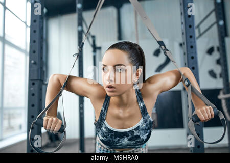 Junge Frau Übungen in der Turnhalle gesunder Lebensstil ziehen Gewichte Stockfoto