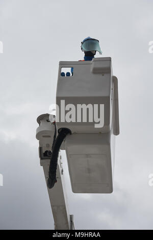 Ein Elektriker (Dummy) in einer einheitlichen arbeitet auf isolierte Antenne Plattform, die sicher auf elektrische Stromleitungen zu arbeiten. Stockfoto