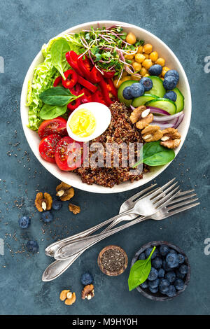 Buddha Schüssel Abendessen mit gekochtem Ei, Kichererbsen, frische Tomaten, Paprika, Gurken, Wirsing, roten Zwiebeln, grünen Sprossen, Spinatblätter, Blaubeere Stockfoto