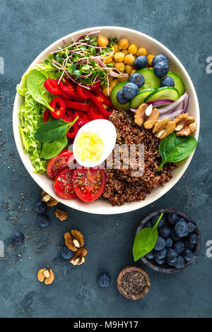 Buddha Schüssel Abendessen mit gekochtem Ei, Kichererbsen, frische Tomaten, Paprika, Gurken, Wirsing, roten Zwiebeln, grünen Sprossen, Spinatblätter, Blaubeere Stockfoto
