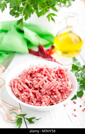 Forcemeat. Rohe Masse Schweinefleisch in der Schüssel auf weißem Küchentisch. Frischem Hackfleisch Stockfoto