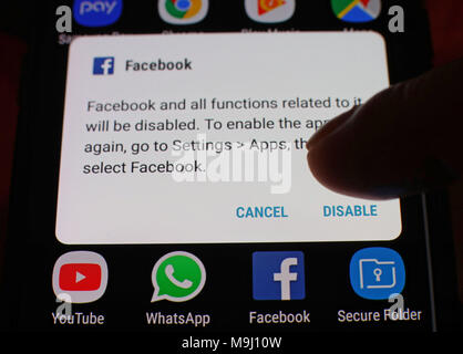 Eine Option, um die Facebook App deaktivieren wird auf dem Bildschirm eines Handys angezeigt, in London. Stockfoto