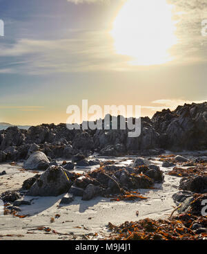 Februar ein sonniger Nachmittag. North East über St. Ronan;'s Bay und der Klang von Iona auf Mull. Mit Felsenküste und Algen. Iona Stockfoto