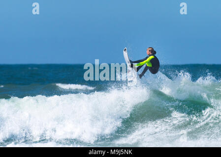 Ein Surfer eine spektakuläre Luftaufnahmen Trick von der Spitze einer Welle an Fistral in Newquay Cornwall. Stockfoto