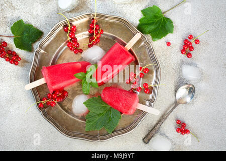 Hausgemachtes Eis Früchte Creme. Eis am Stiel der roten Johannisbeere Limonade. Frozen Drinks. Ansicht von oben. Stockfoto