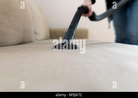 Frau Reinigung das Sofa, Couch mit Staubsauger Stockfoto