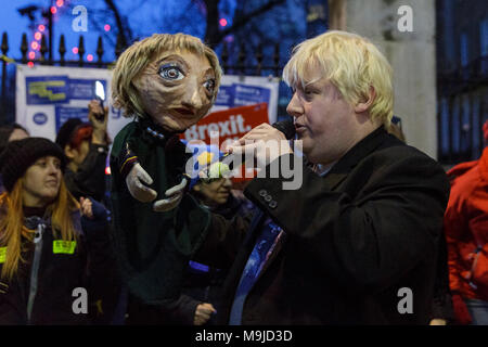 Westminster, London, 26. März 2018. Zeichnete Galdron, als Faux Bojo, Boris Johnson Imitator von London bekannt, tritt in die pro-europäische, Anti-Brexit Demonstranten vor Downing Street für einen Abend singalong mit seinem Theresa May Marionette. Credit: Imageplotter Nachrichten und Sport/Alamy leben Nachrichten Stockfoto