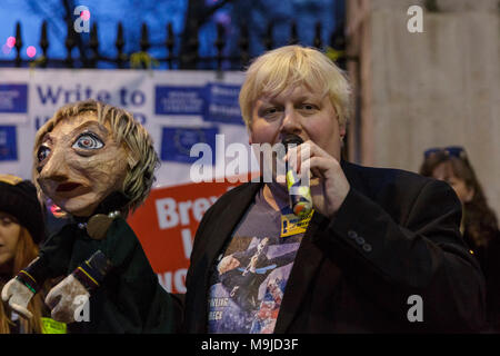 Westminster, London, 26. März 2018. Zeichnete Galdron, als Faux Bojo, Boris Johnson Imitator von London bekannt, tritt in die pro-europäische, Anti-Brexit Demonstranten vor Downing Street für einen Abend singalong mit seinem Theresa May Marionette. Credit: Imageplotter Nachrichten und Sport/Alamy leben Nachrichten Stockfoto