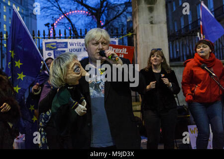 Westminster, London, 26. März 2018. Zeichnete Galdron, als Faux Bojo, Boris Johnson Imitator von London bekannt, tritt in die pro-europäische, Anti-Brexit Demonstranten vor Downing Street für einen Abend singalong mit seinem Theresa May Marionette. Credit: Imageplotter Nachrichten und Sport/Alamy leben Nachrichten Stockfoto