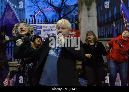 Westminster, London, 26. März 2018. Zeichnete Galdron, als Faux Bojo, Boris Johnson Imitator von London bekannt, tritt in die pro-europäische, Anti-Brexit Demonstranten vor Downing Street für einen Abend singalong mit seinem Theresa May Marionette. Credit: Imageplotter Nachrichten und Sport/Alamy leben Nachrichten Stockfoto