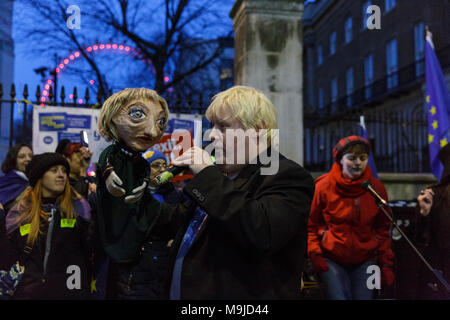 Westminster, London, 26. März 2018. Zeichnete Galdron, als Faux Bojo, Boris Johnson Imitator von London bekannt, tritt in die pro-europäische, Anti-Brexit Demonstranten vor Downing Street für einen Abend singalong mit seinem Theresa May Marionette. Credit: Imageplotter Nachrichten und Sport/Alamy leben Nachrichten Stockfoto