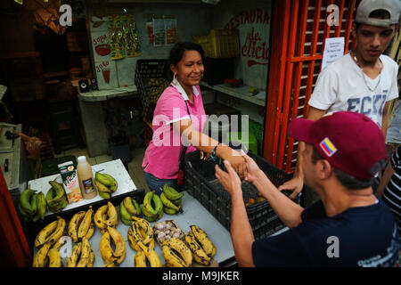 26 März 2018, Venezuela, Caracas: Kandidat der Opposition Henri Falcon Gruß eine Frucht Hawker im Slum von Petare. Der ehemalige Gouverneur brach der Boykott, der von den wichtigsten Opposition Koalition, Schlamm, und Angemeldet als Präsidentschaftskandidaten. Maduro sucht für eine Amtszeit endet im Jahr 2025 während der kommenden Wahlen vom 20. Mai wiedergewählt werden. Beobachter befürchten, dass die Wahlen weder frei noch fair. Foto: Wil Riera/dpa Stockfoto